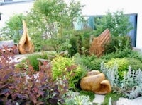 a garden with a lot of plants and sculptures