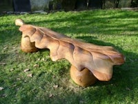 a wooden bench made out of oak leaves