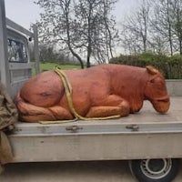 a large wooden horse laying in the back of a truck