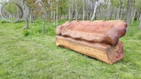a wooden bench in the middle of a grassy field
