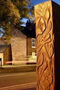 a carved wooden pole in the middle of a street