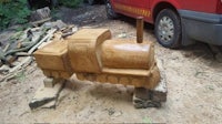 a wooden train is sitting on top of a piece of wood