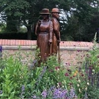 a statue of a man and a woman in a garden