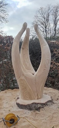 a sculpture made out of wood in a wooded area