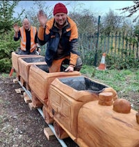 two men standing next to a wooden train
