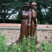 a statue of a man and a woman in a garden