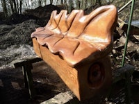 a bench made out of wood in a wooded area