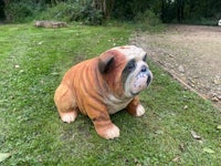a statue of a bulldog sitting on the grass