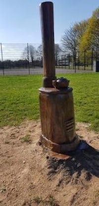 a statue of a stove in the middle of a field