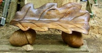 a wooden bench with a leaf on it