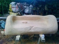 a large stone bench is being made in a yard