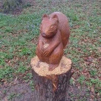 a sculpture of a squirrel sitting on a tree stump