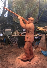 a wooden statue of a man holding a gun