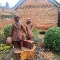 a statue of a man and a woman in a garden