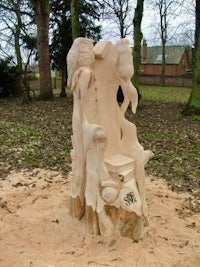 a carved tree stump in the middle of a field