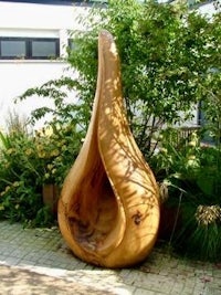 a large wooden sculpture in the middle of a garden