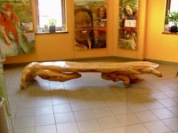 a wooden bench in a room with pictures on it