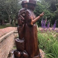 a statue of a woman and a man in a garden