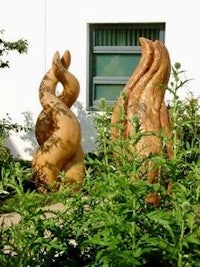 two wooden sculptures in front of a building