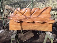 a wooden bench with a leaf on it