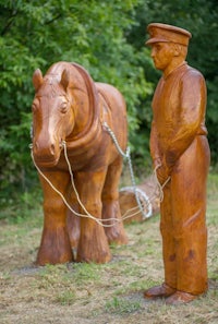 a wooden statue of a man and a horse