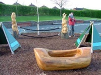 a wooden boat play area in a park