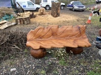 a wooden bench with a leaf on it