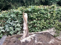a sculpture made from a tree stump in a garden