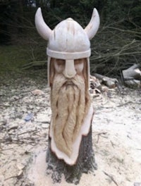 a carving of a viking head on a tree stump