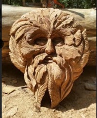 a wood carving of a green man on a log
