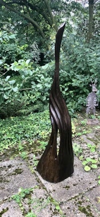 a large bronze sculpture in the middle of a wooded area