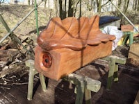 a wooden bench made out of wood in a wooded area