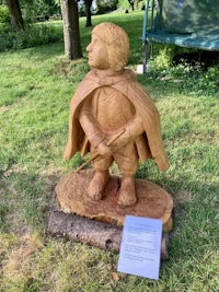 a wooden carving of a man with a cape